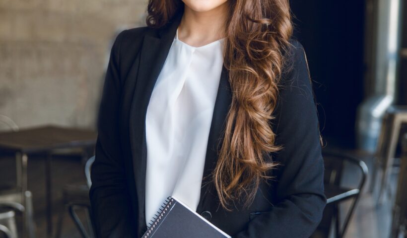 brunette-business-woman-with-wavy-long-hair-blue-eyes-stands-holding-notebook-hands (1)