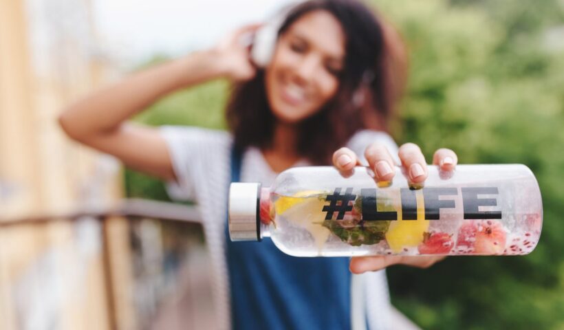 outdoor-portrait-smiling-black-girl-white-shirt-with-bottle-her-hand-foreground_11zon