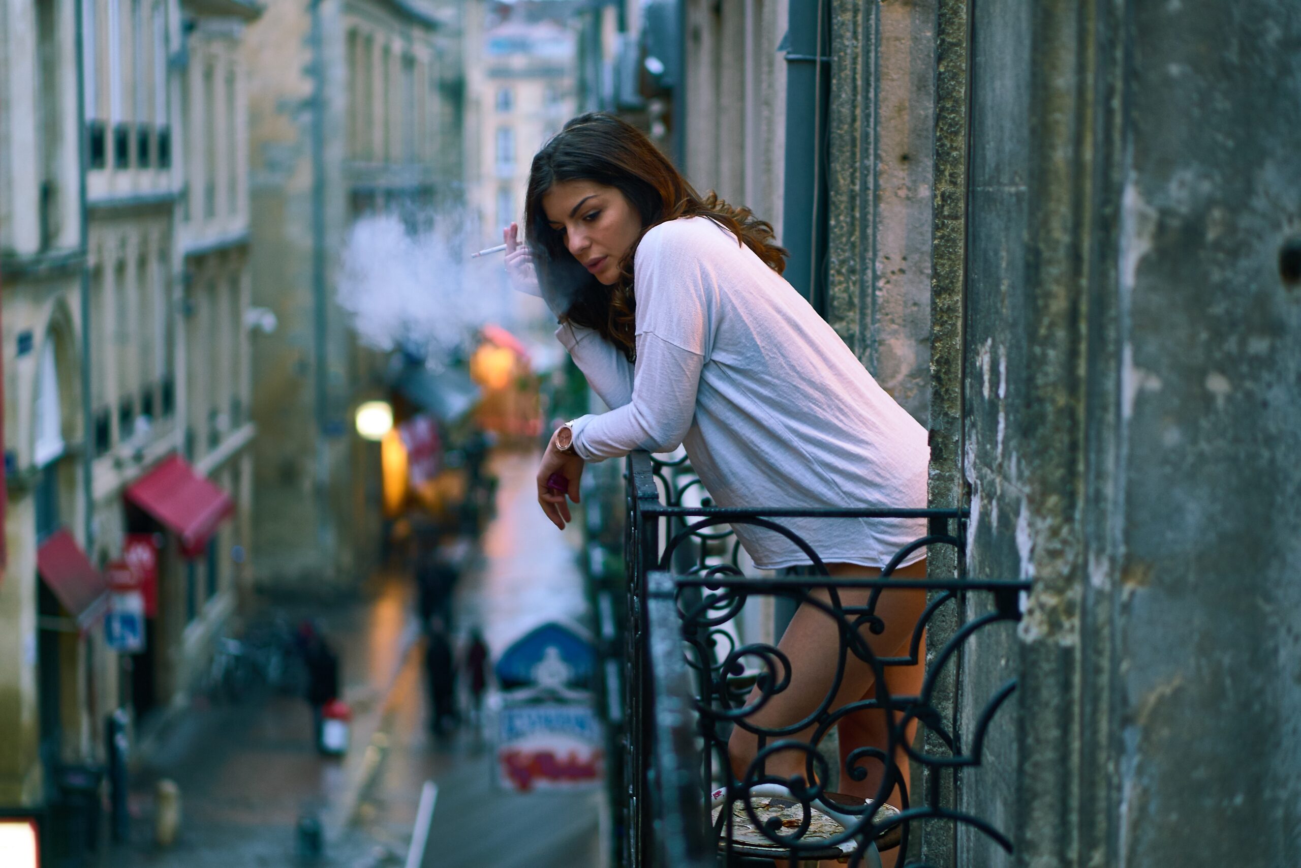 Women is smoking at the balcony of her apartment