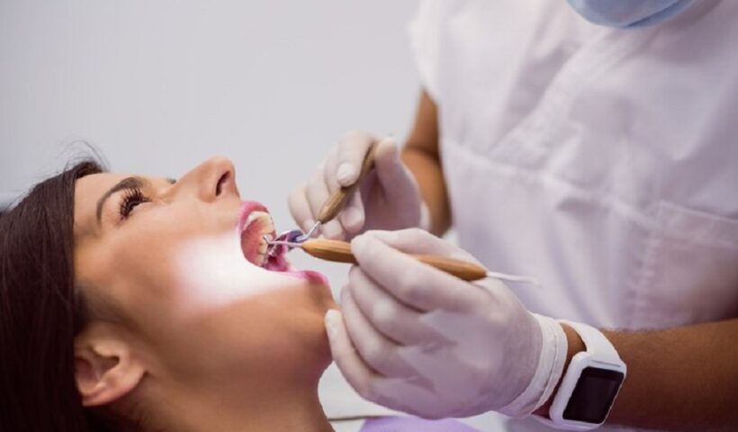 dentist-examining-female-patient-teeth_107420-65301