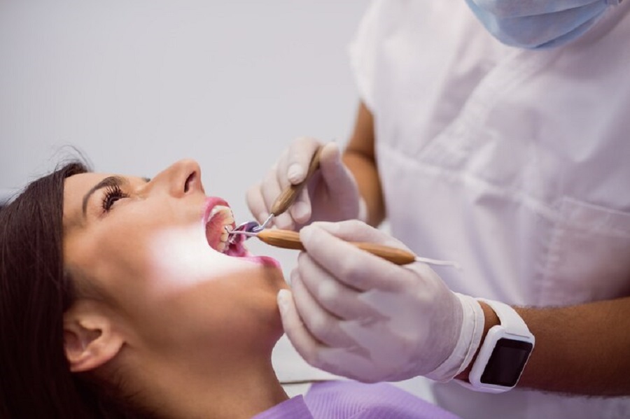 dentist-examining-female-patient-teeth_107420-65301