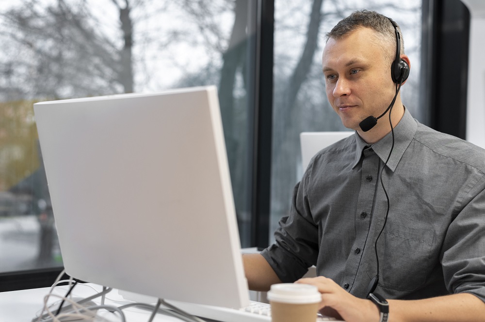 man-working-call-center-with-headphones-computer-min